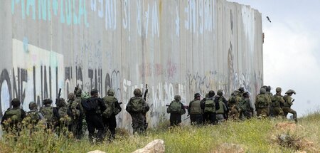 Während hinter der Mauer mit Protesten an die Nakba erinnert wir...